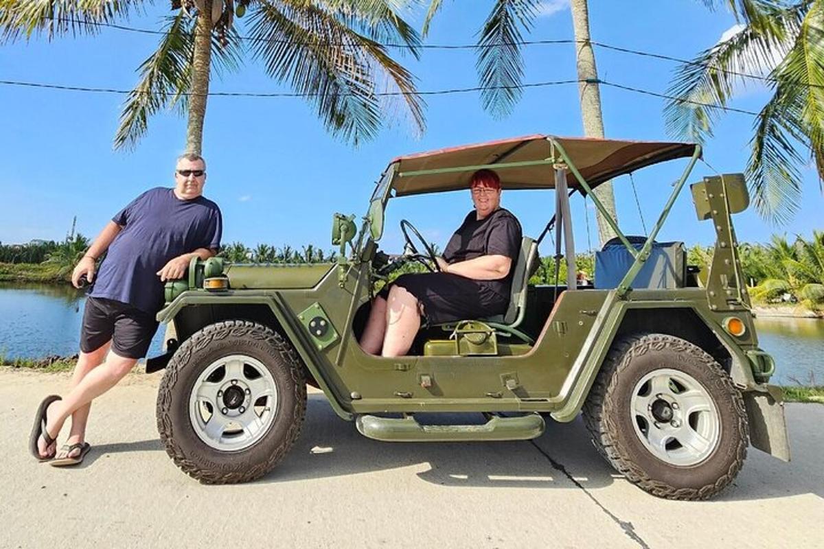 dva moška sedita v zelenem džipu na plaži