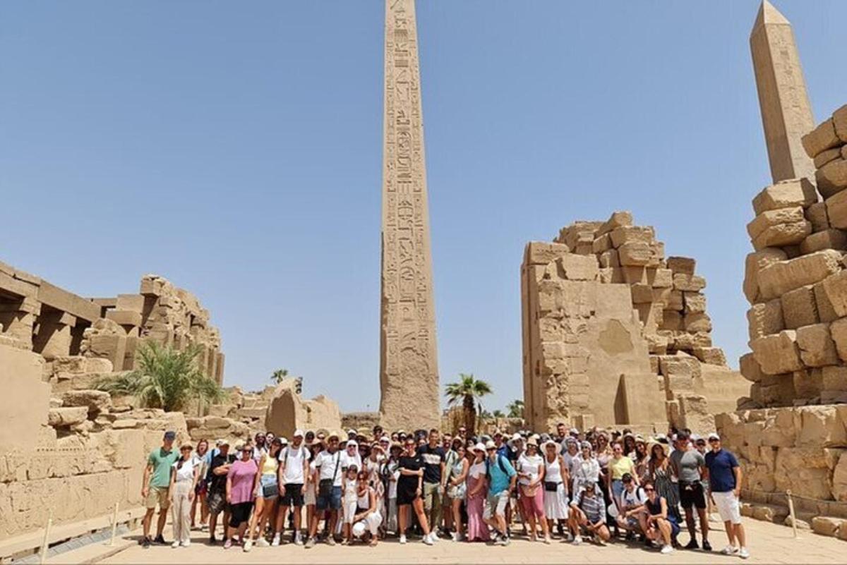 um grupo de pessoas em pé em frente a um obelisco