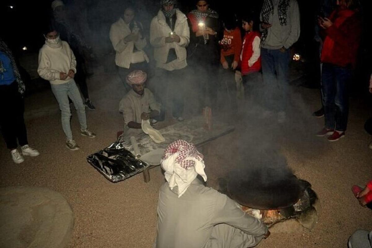 skupina ljudi koji stoje oko lomače
