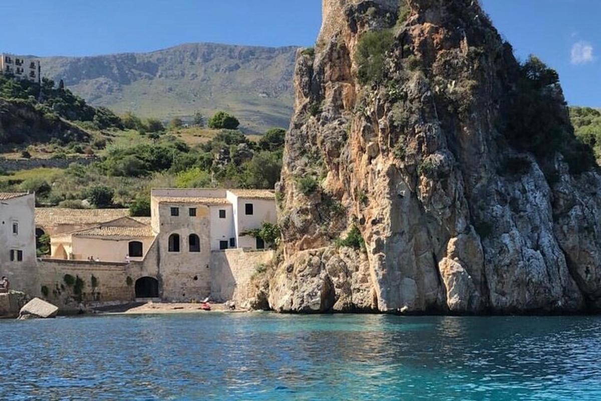 a group of buildings on the water next to a mountain