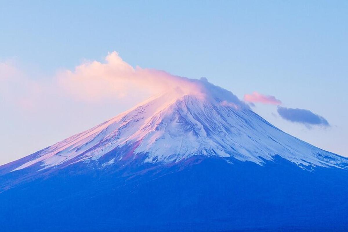 una montagna coperta di neve e nuvole nel cielo