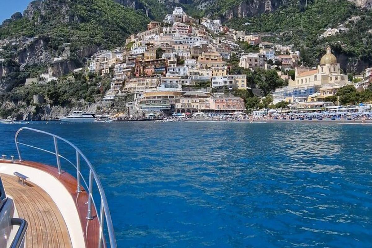 Un barco en el agua junto a un pueblo en una montaña.