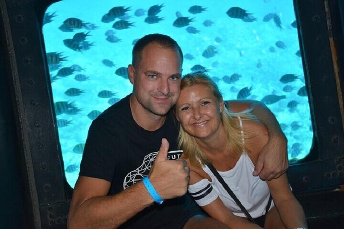 a man and a woman posing for a picture in front of an aquarium