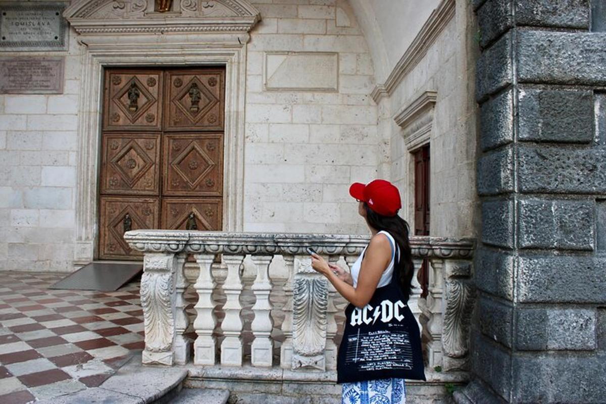 žena stojící vedle budovy a dívající se do svého mobilního telefonu
