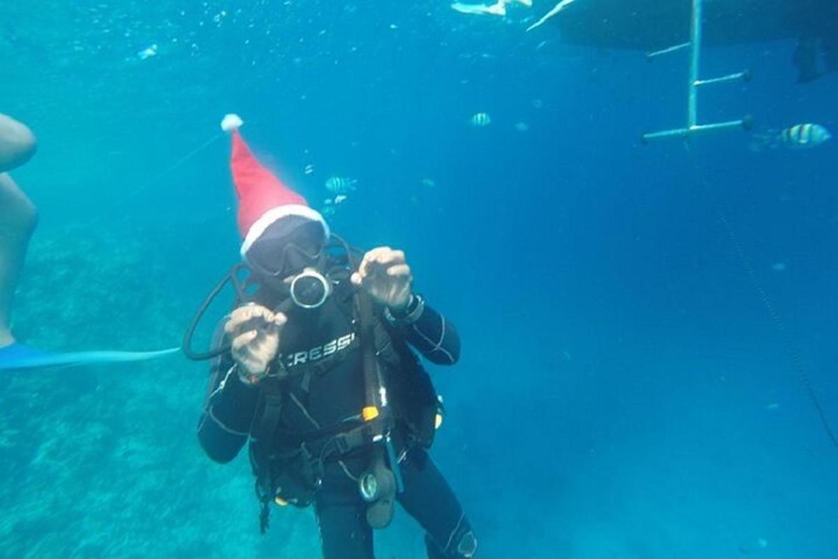 una persona con un cappello da Babbo Natale e una macchina fotografica in acqua