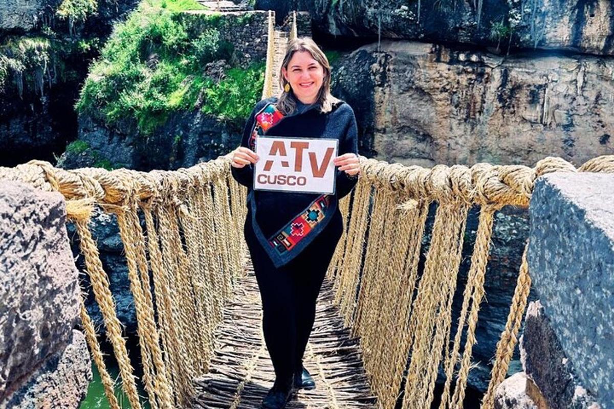 Una mujer parada en un puente de cuerda sosteniendo un cartel