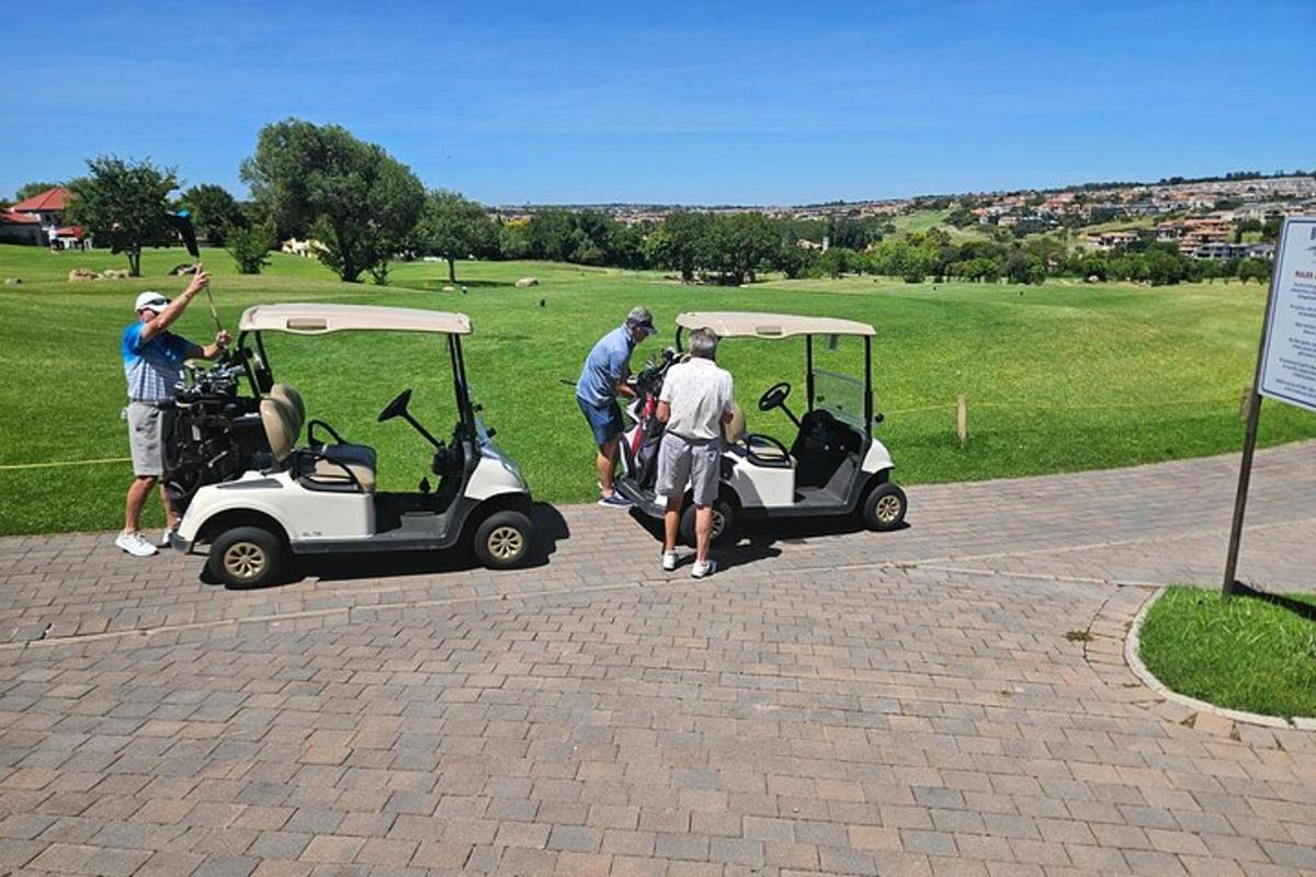 egy csoport ember áll golfkocsik mellett