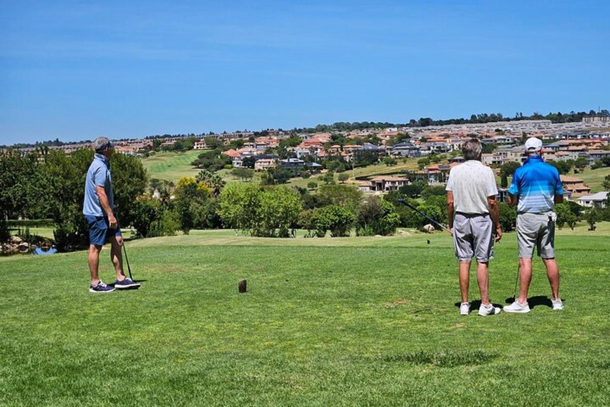 három férfi áll egy golfpályán