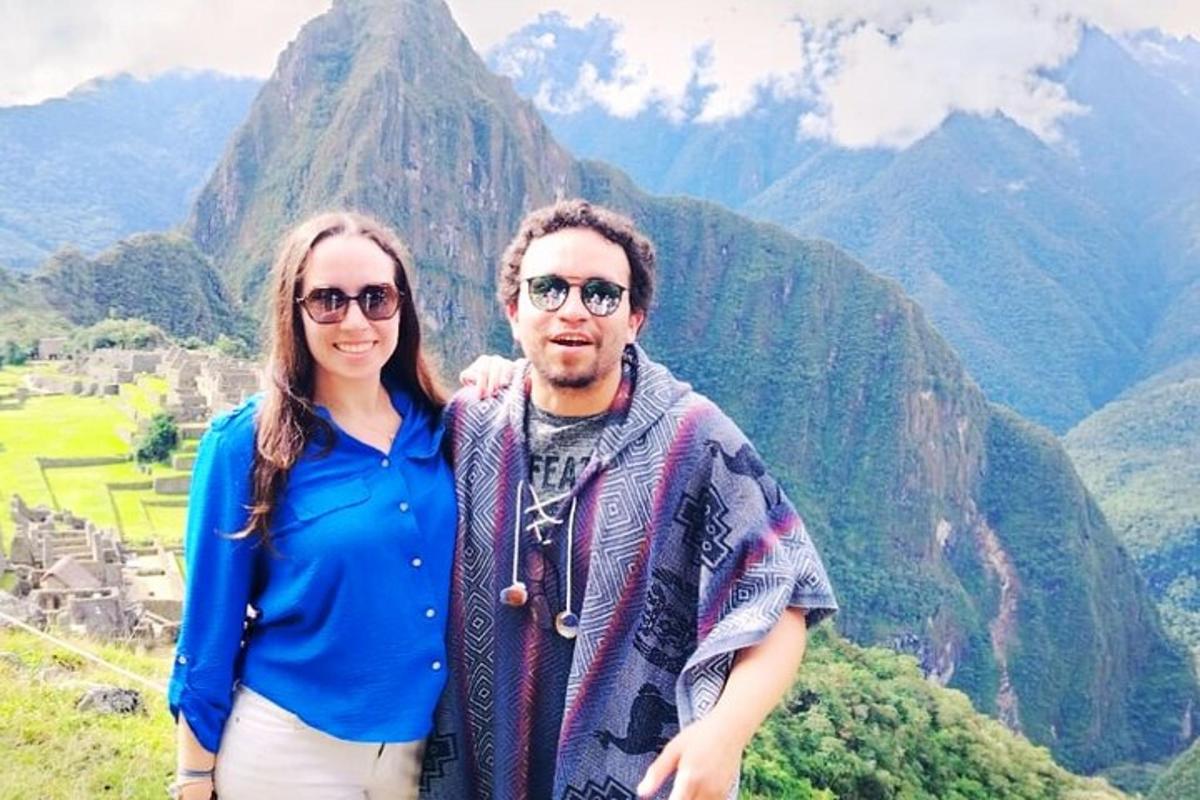 um homem e uma mulher em pé em frente a uma montanha
