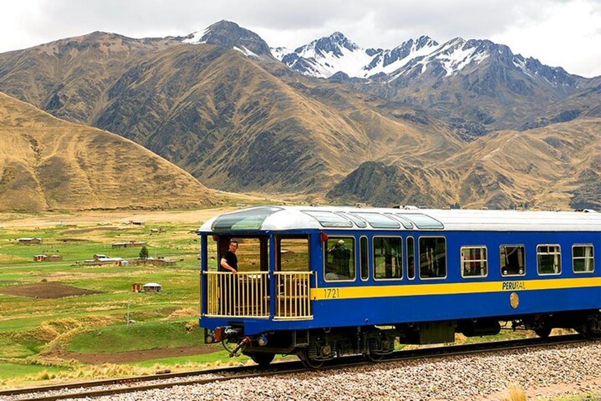 รถไฟสีน้ำเงินและสีเหลืองกำลังวิ่งผ่านเทือกเขา