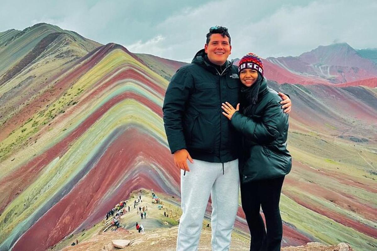 un homme et une femme debout devant une montagne