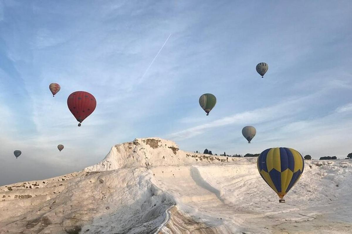 مجموعة من البالونات الهوائية الساخنة تحلق فوق جبل مغطى بالثلوج
