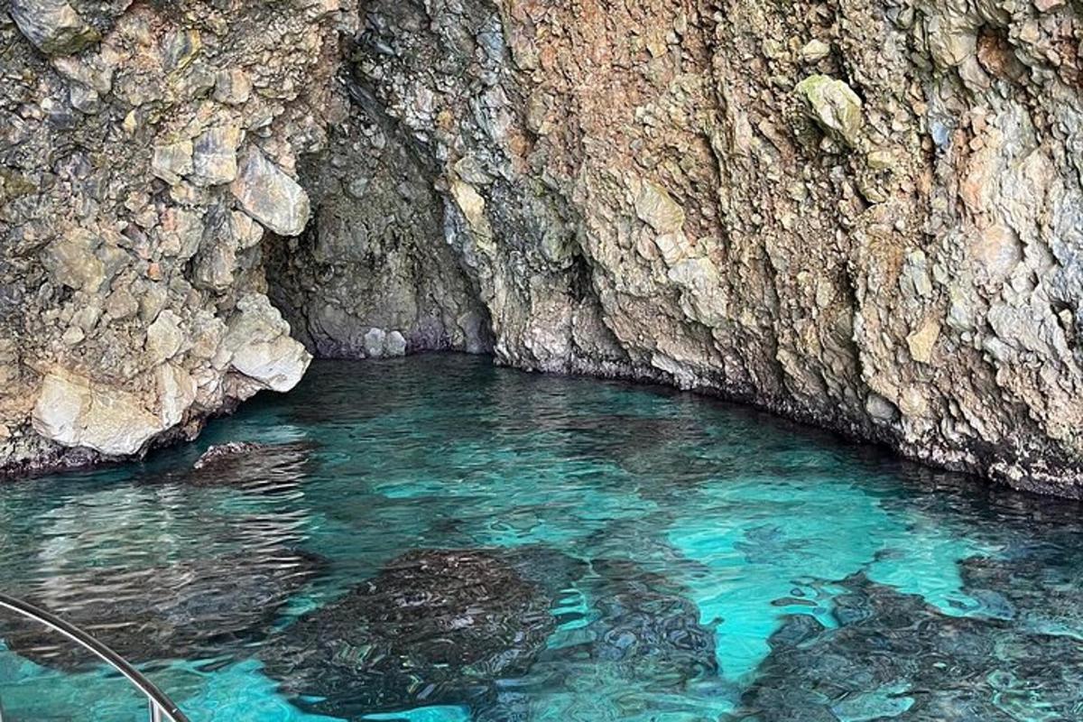 una piscina di acqua blu accanto a un muro di pietra