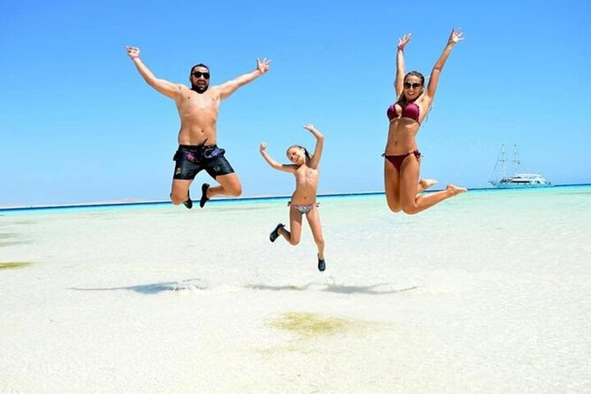 un grup de tres persones saltant a la platja