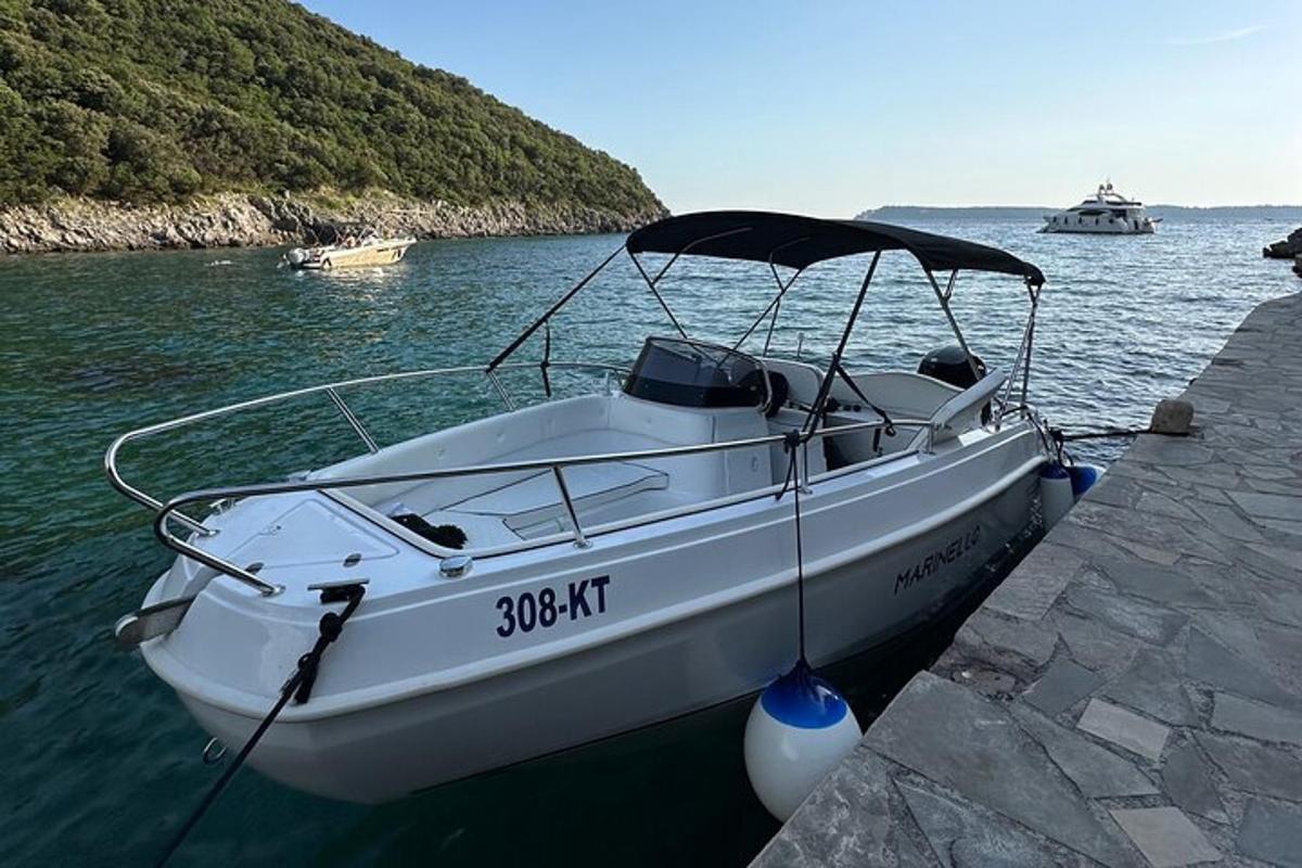 a white boat tied to a dock in the water