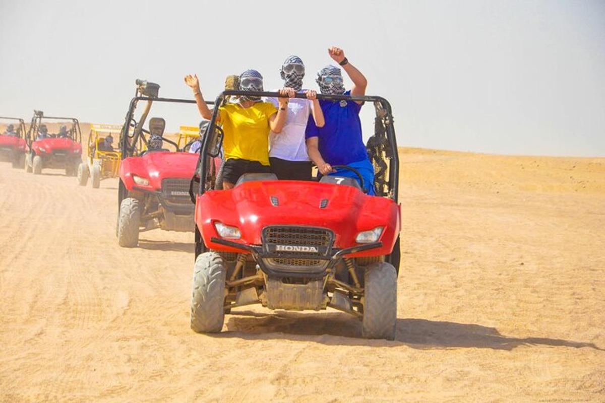 um grupo de pessoas andando em um quadriciclo no deserto