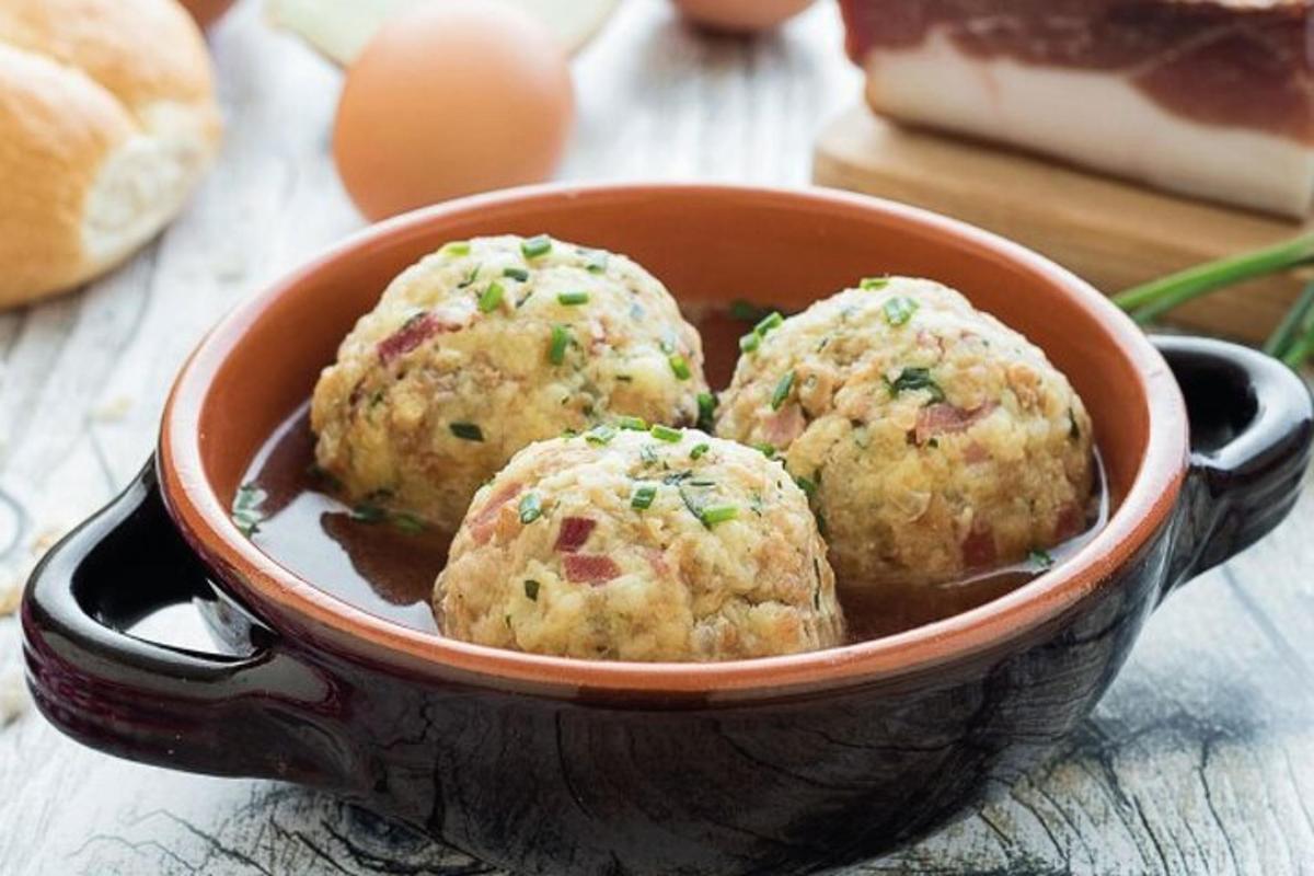 a bowl with three meatballs in a dipping sauce