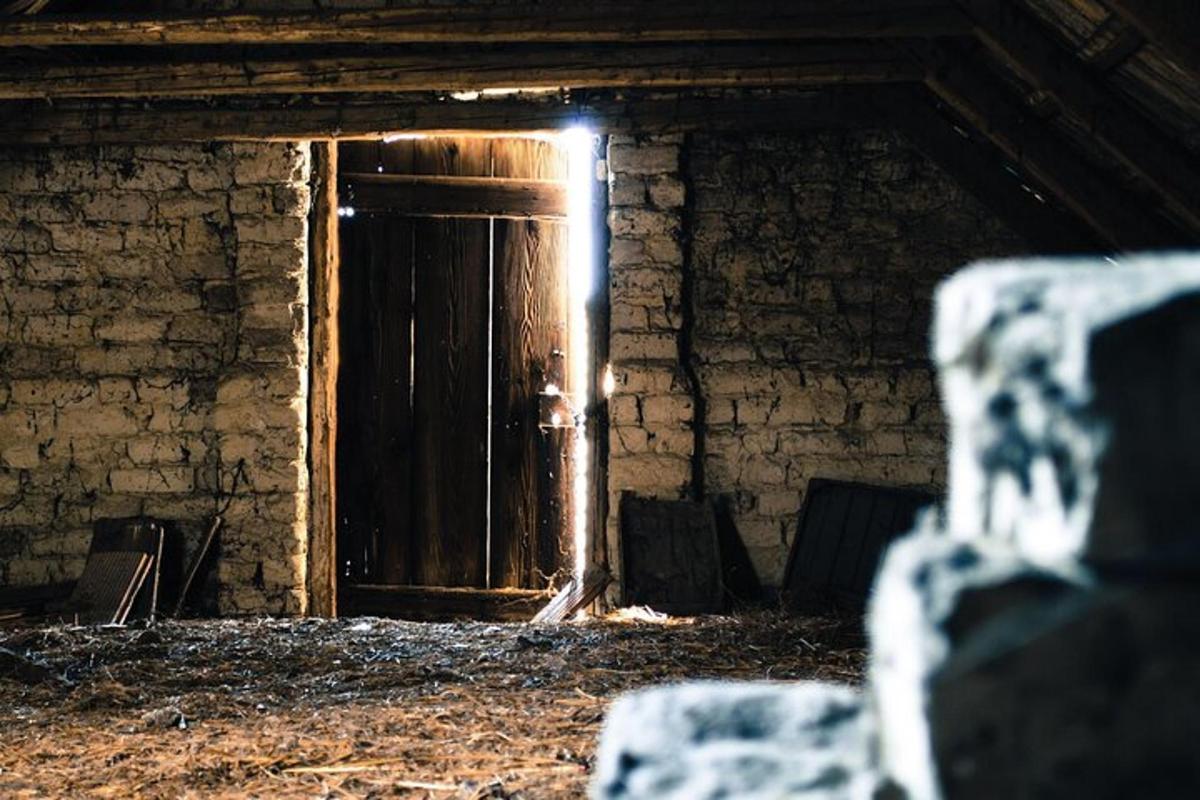 uma porta de madeira em uma sala com uma parede de tijolos
