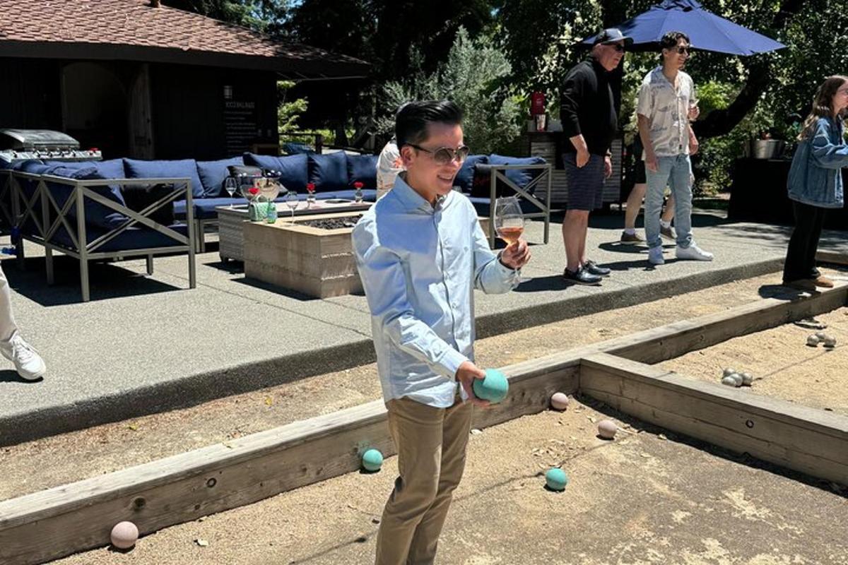 a man holding a glass of wine and some balls