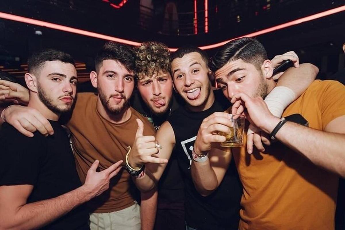 skupina mužů pózujících pro fotografii na večírku