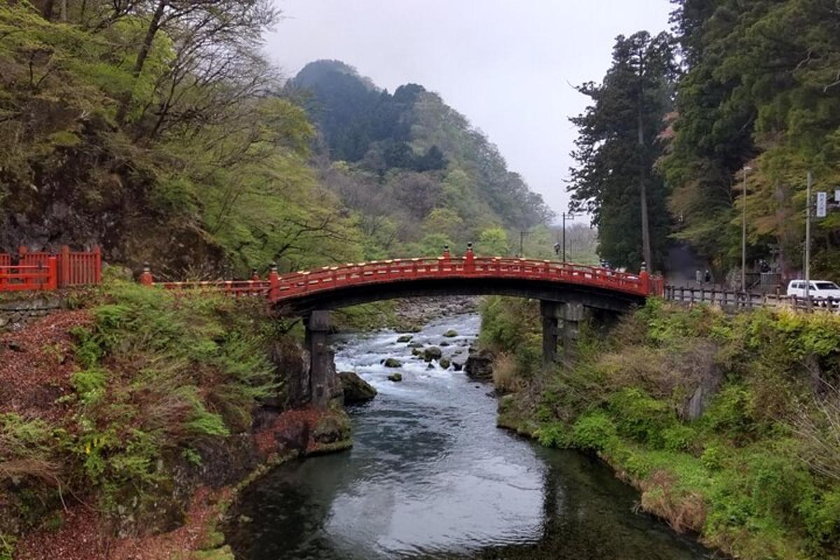 un ponte rosso sopra un fiume in una montagna