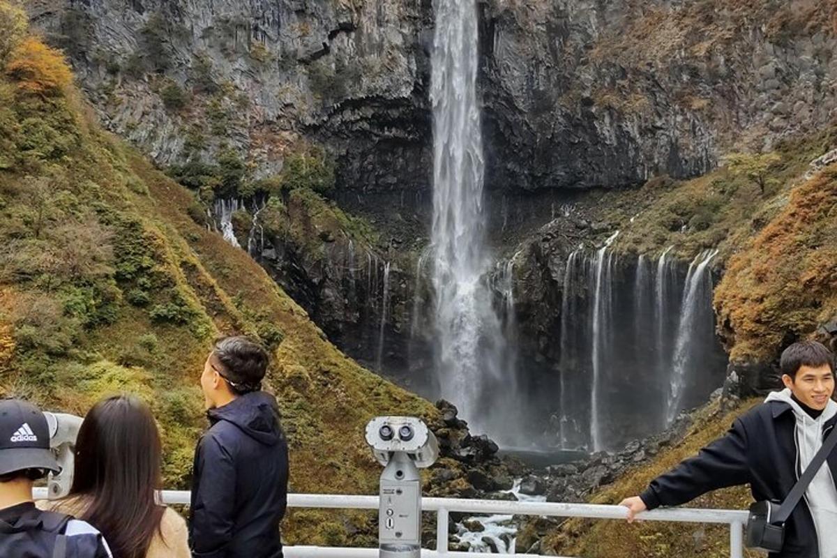 un gruppo di persone in piedi davanti a una cascata