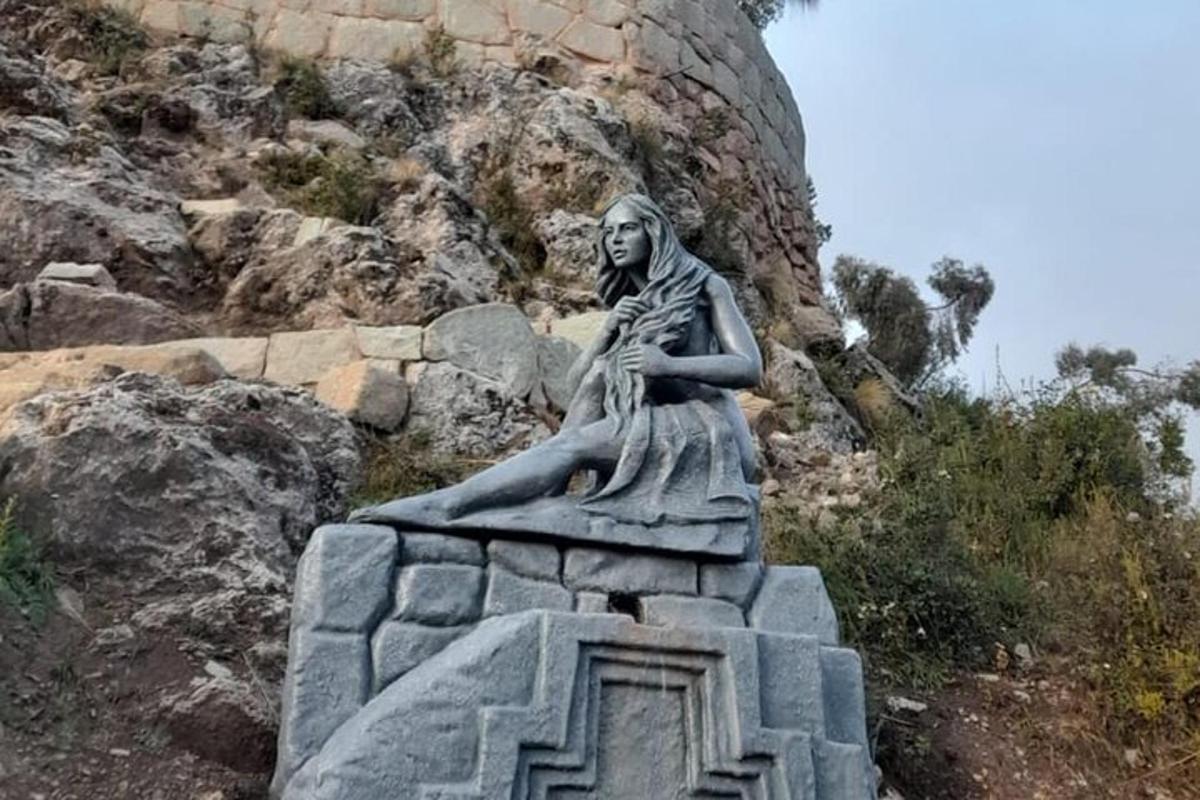 a statue of a woman sitting on a rock