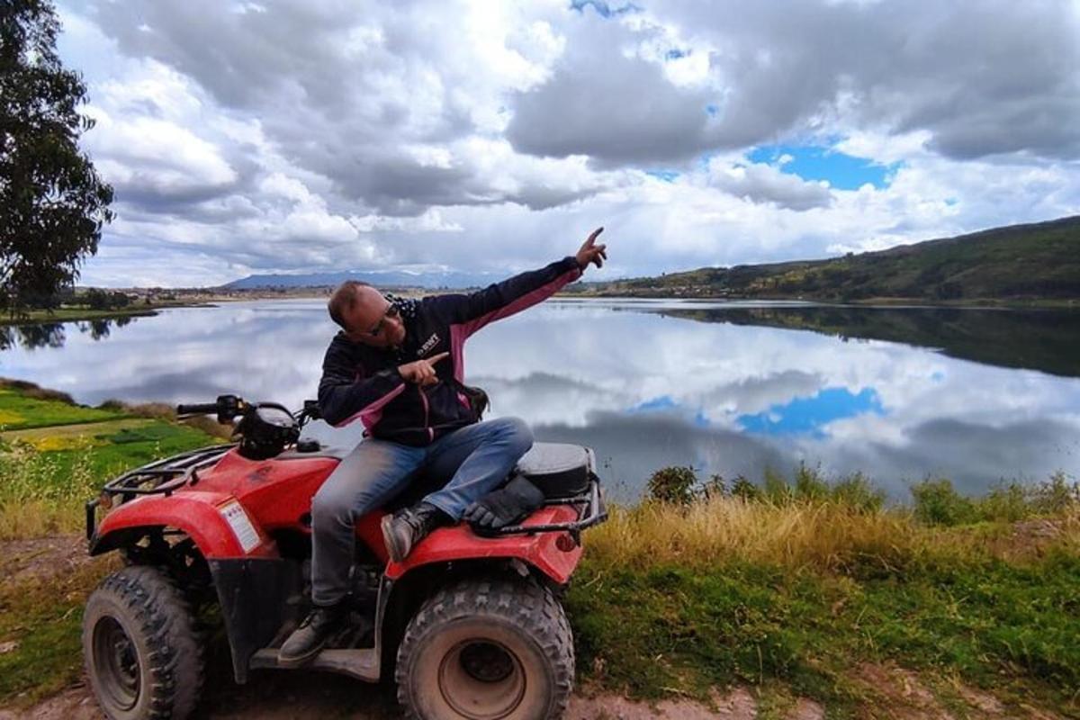 seorang pria duduk di atas ATV di sebelah danau