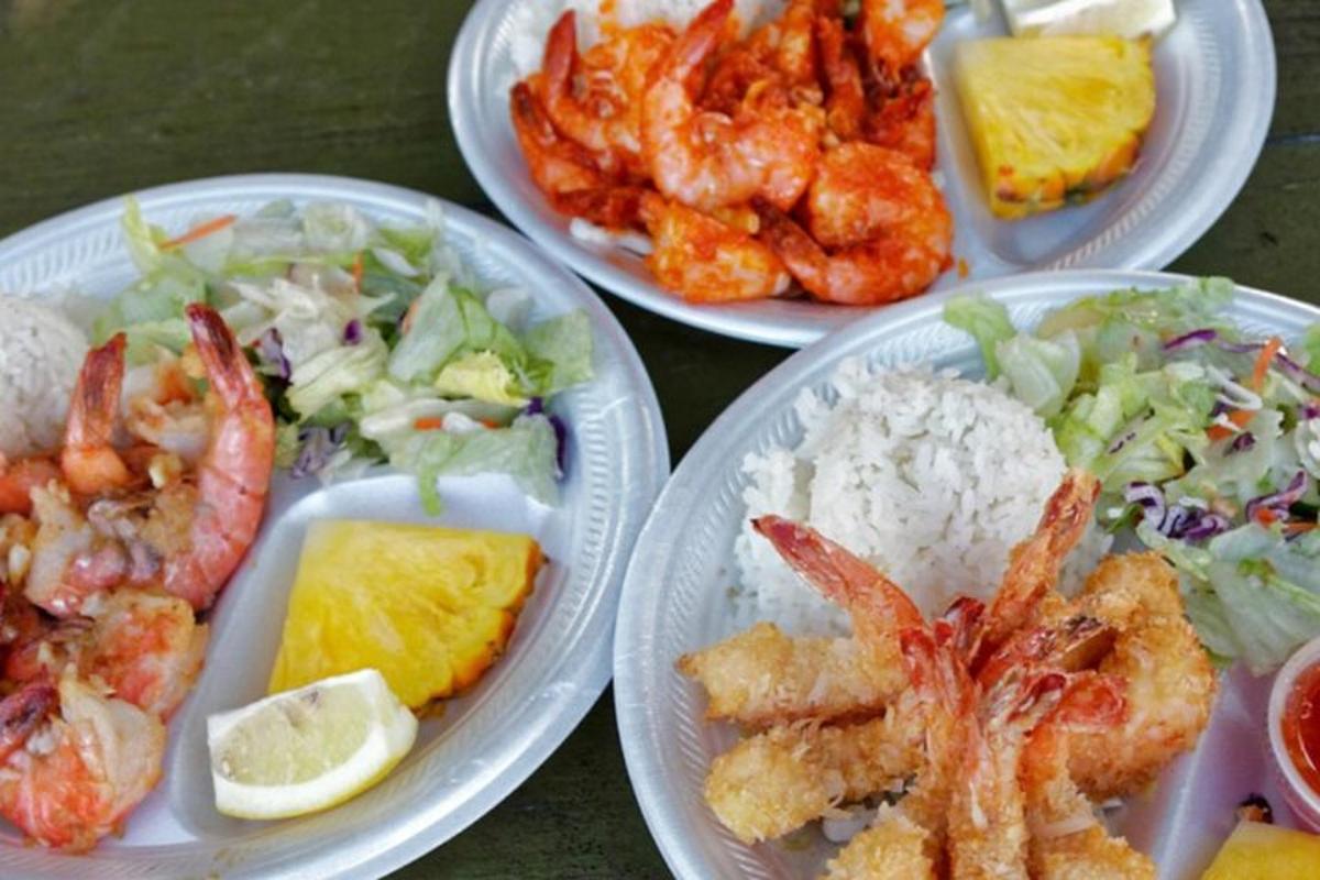 quatre plats de menjar amb gambes i arròs sobre una taula