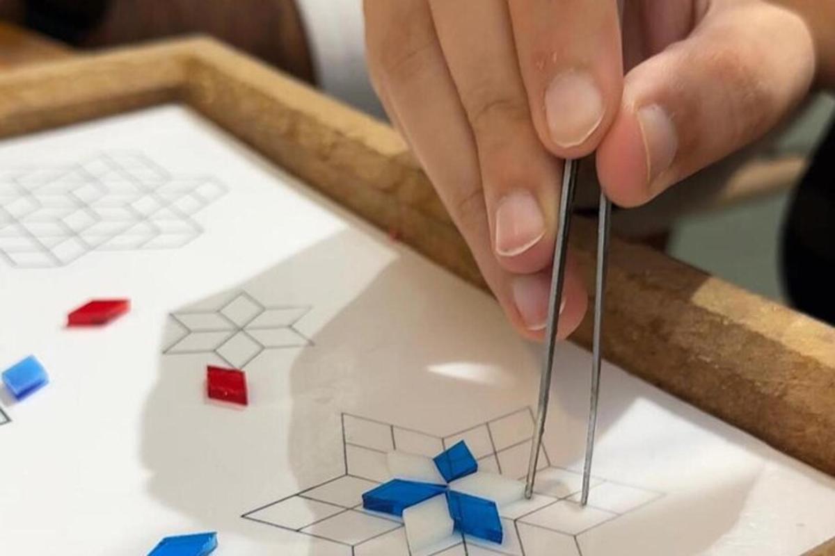 een persoon die een model van een huis met een schaar uitknipt