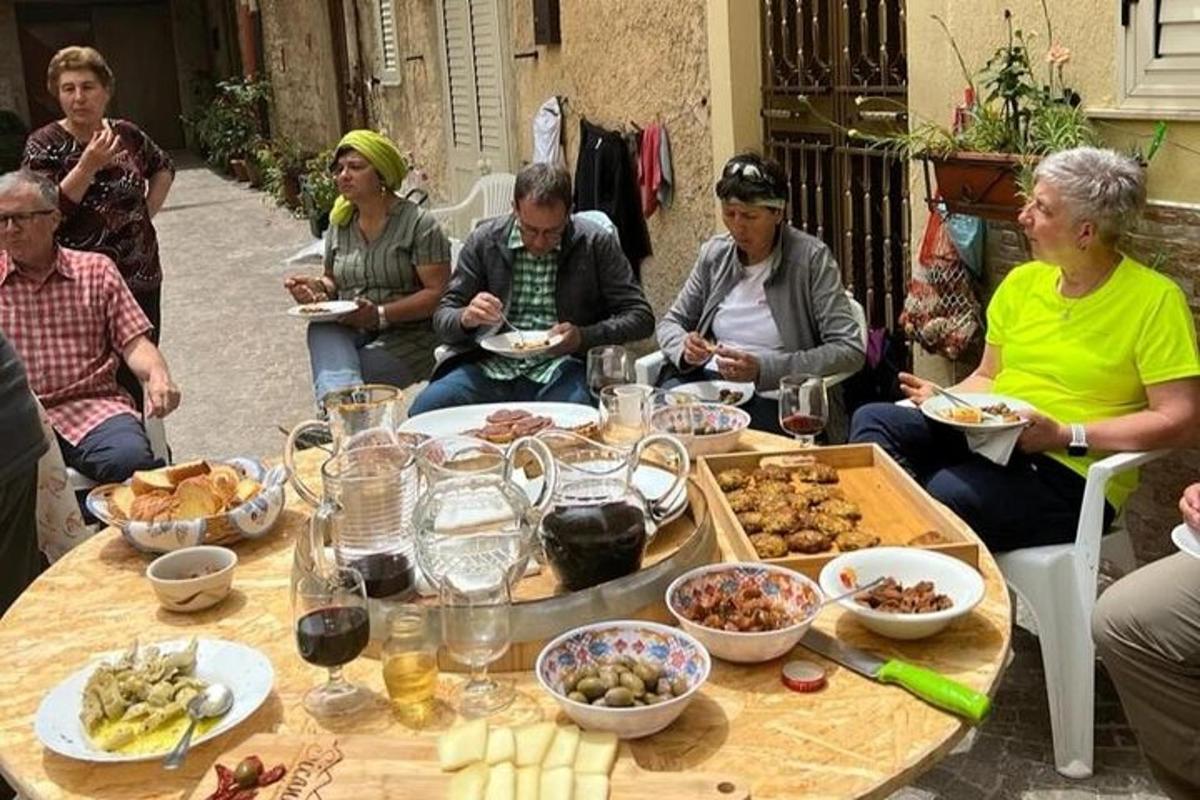 skupina ljudi, ki sedijo okoli mize s hrano