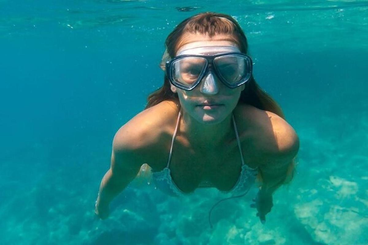 una donna in costume da bagno e occhialini in acqua