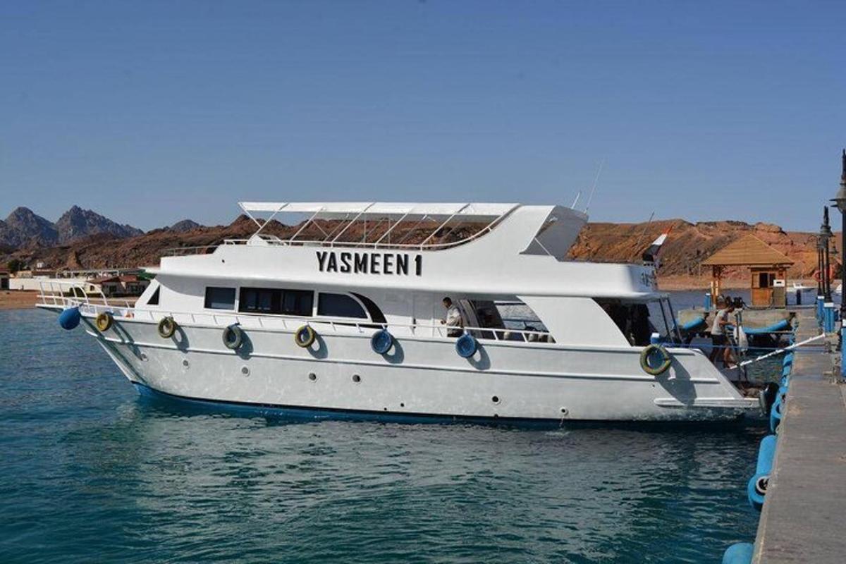 una barca bianca nell'acqua accanto a un molo