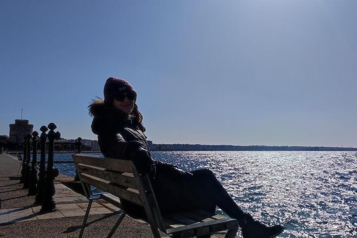 žena sedící na lavičce u vody