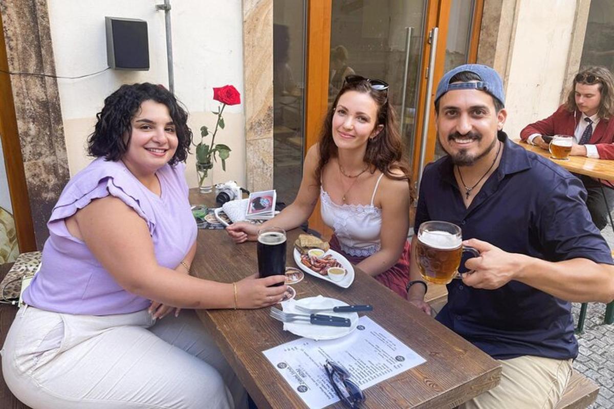 skupina lidí sedících u stolu s pivem