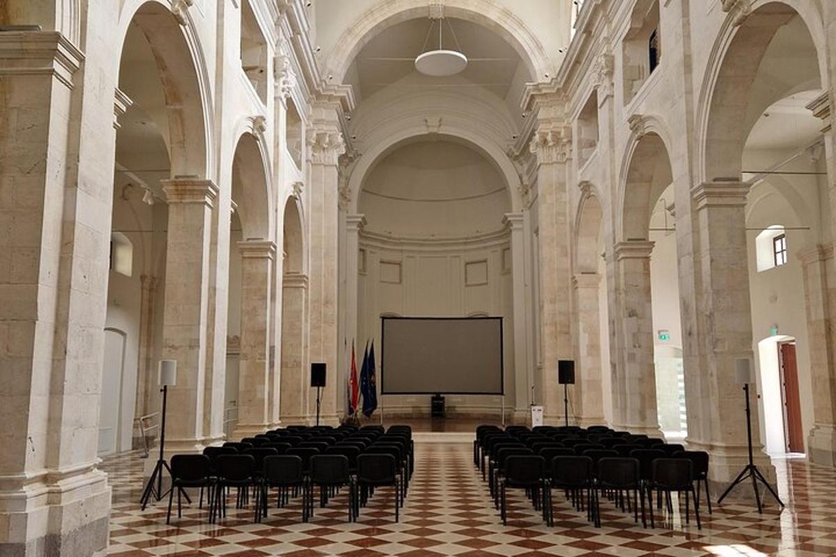 a large room with chairs and a screen in a building