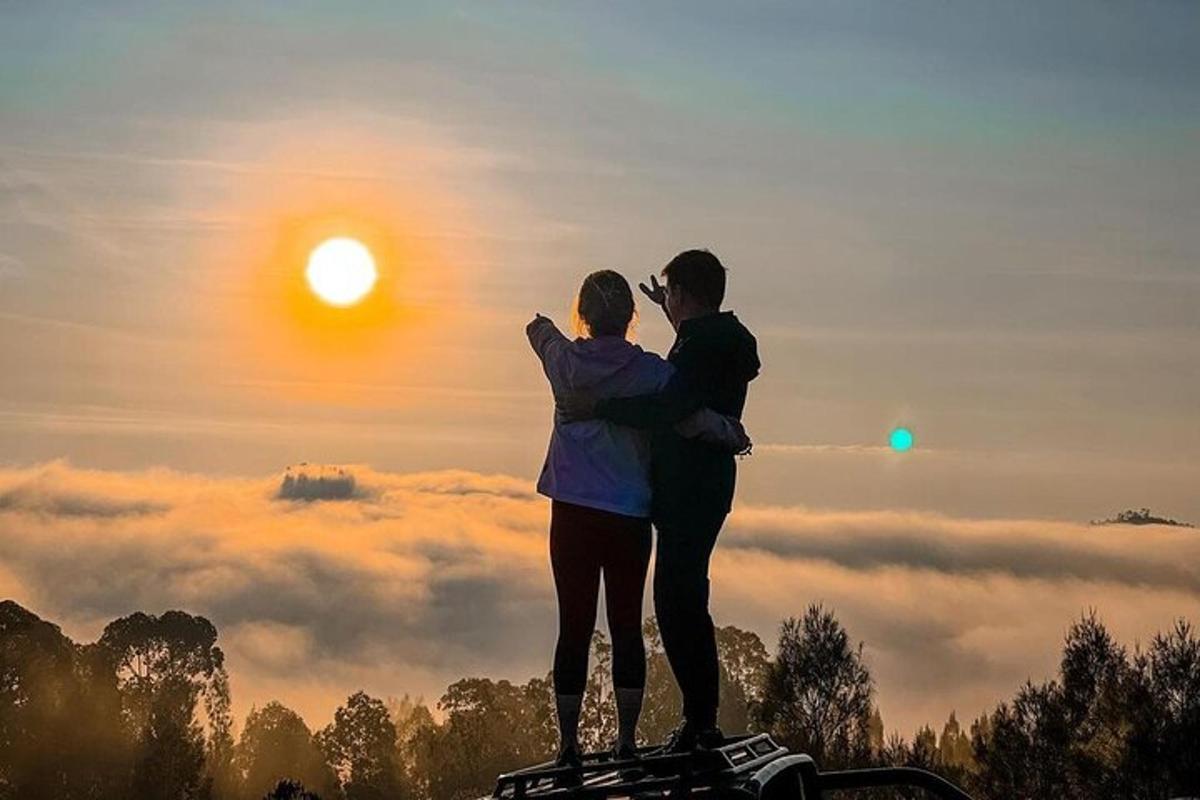 Maður og kona standa á hæð með sólinni uppi