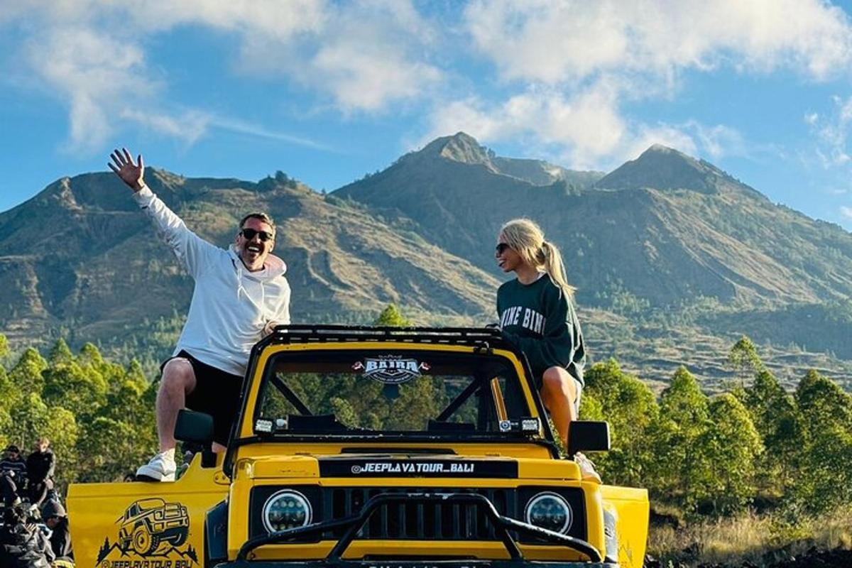 un bărbat și o femeie stând pe acoperișul unui jeep