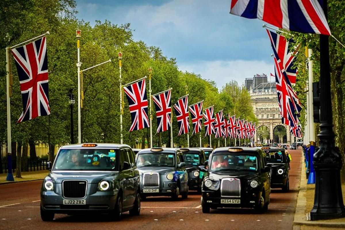 Una fila de coches circulando por una calle con banderas británicas.