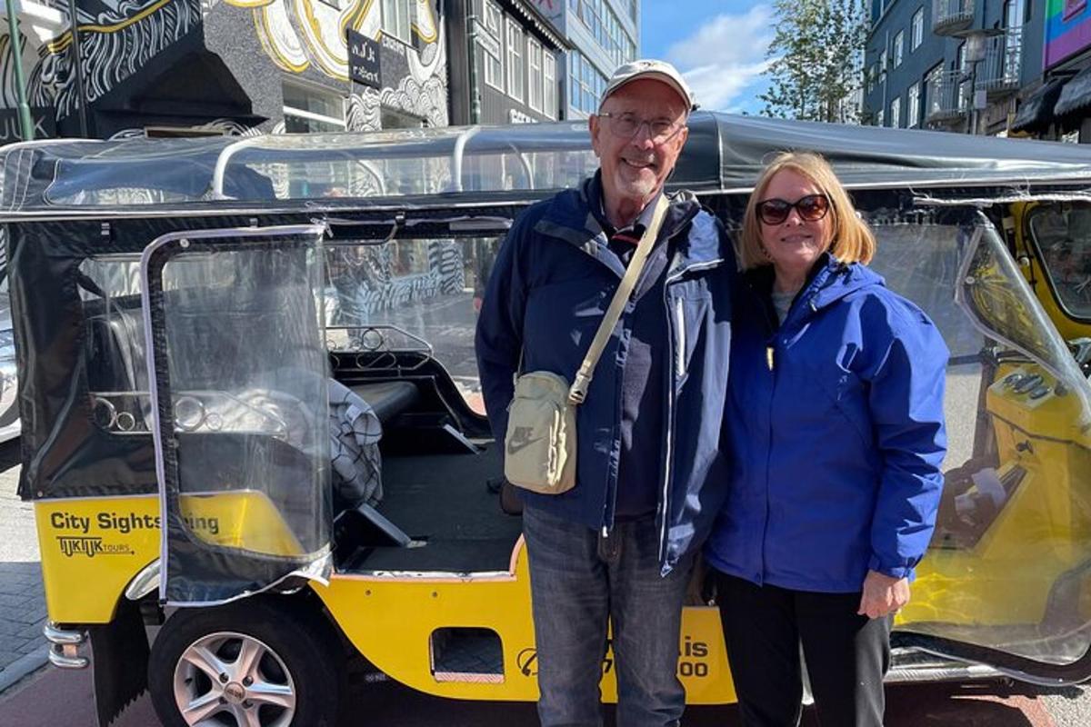 un uomo e una donna in piedi davanti a un golf cart