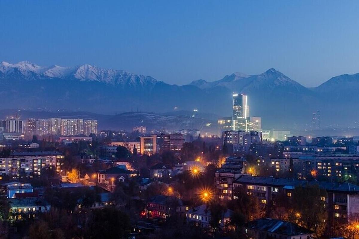 una città di notte con le montagne sullo sfondo