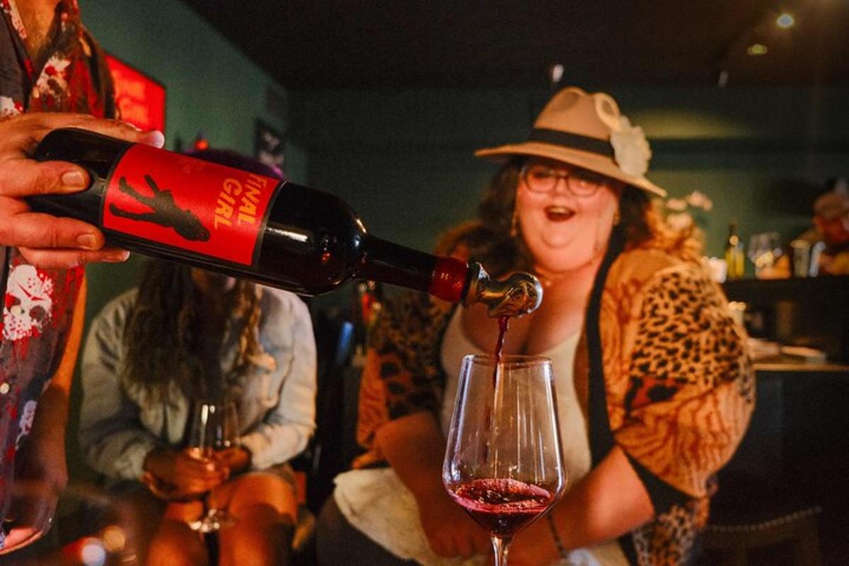 uma mulher está servindo uma taça de vinho tinto