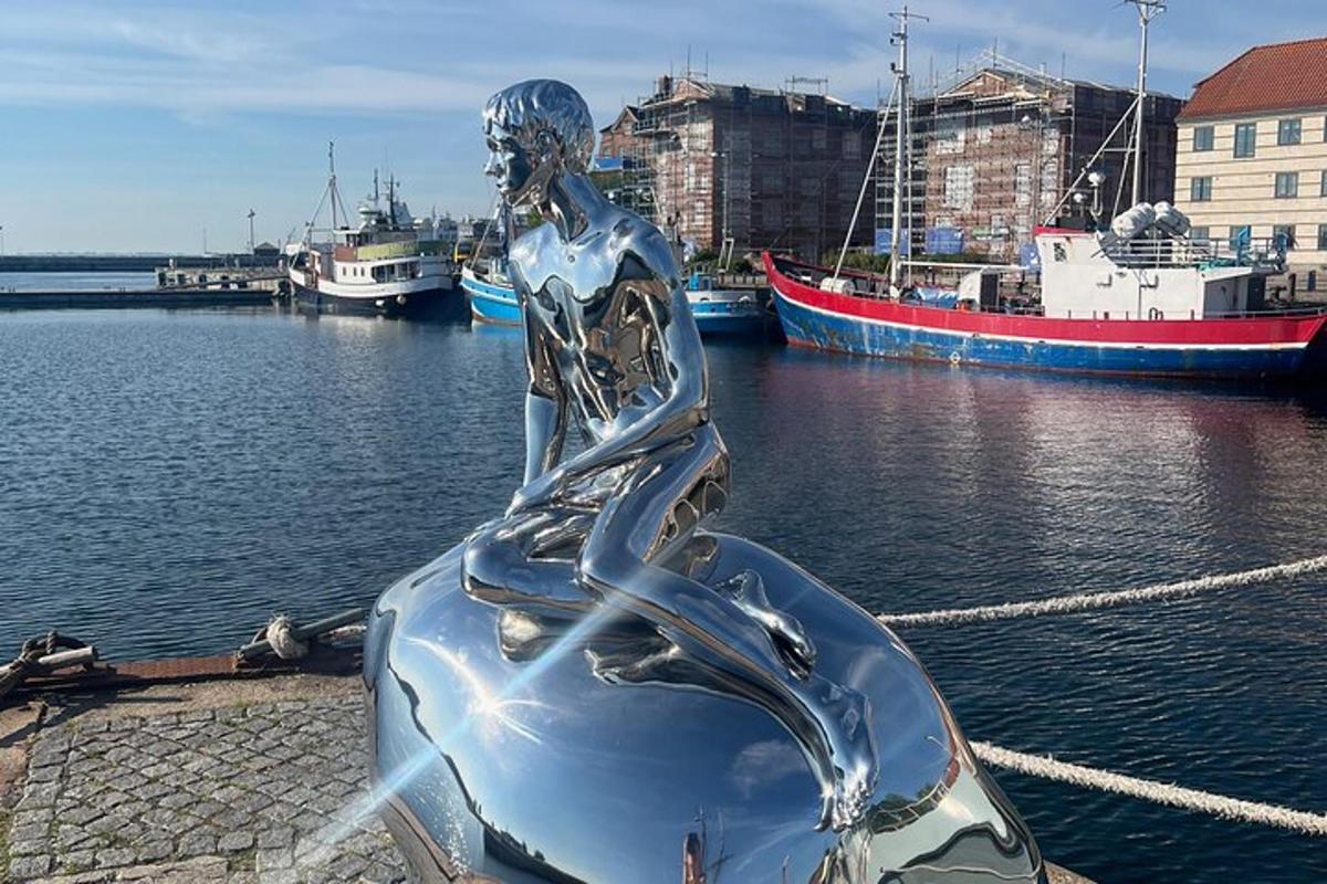a statue of a woman sitting on a boat in the water