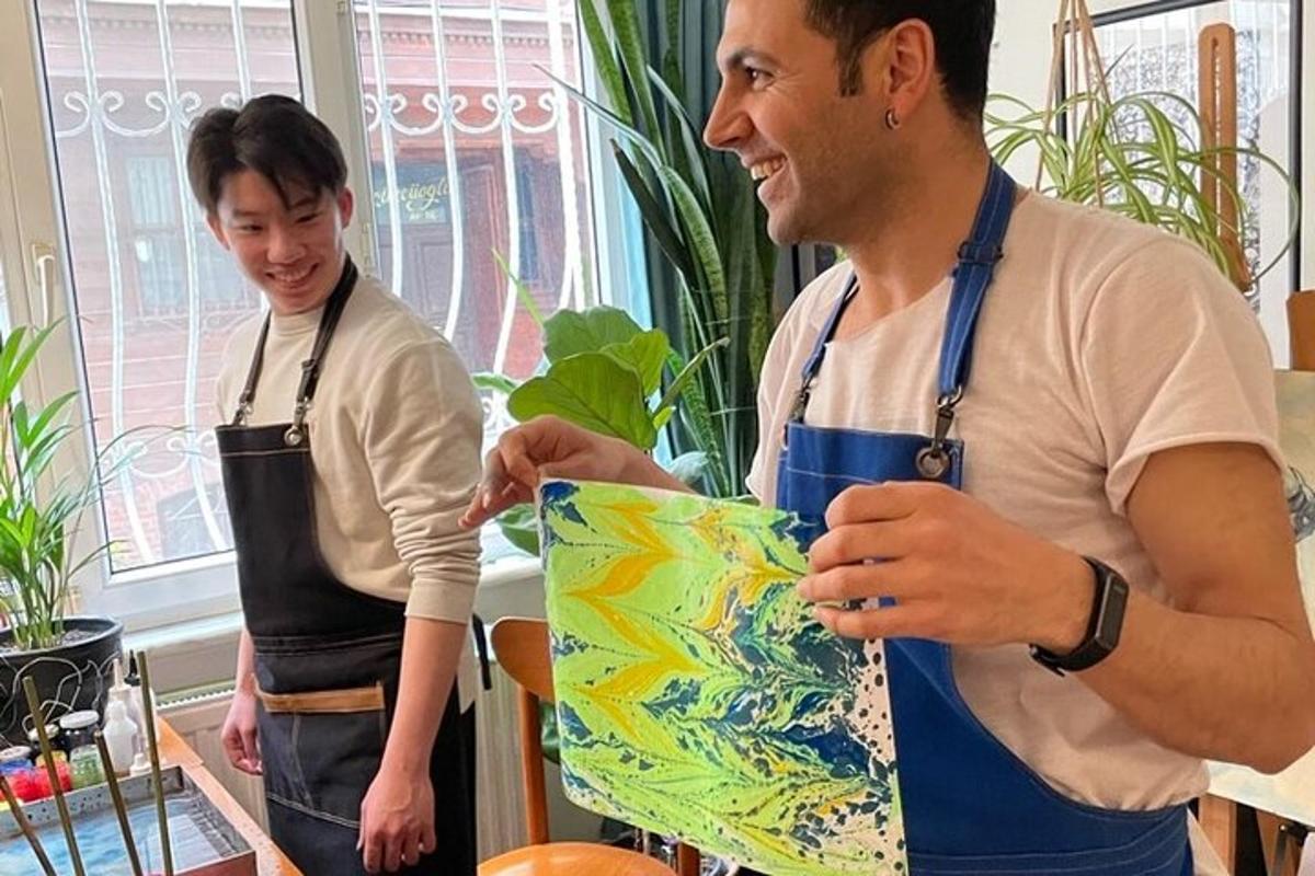 two men standing in a room holding a painting