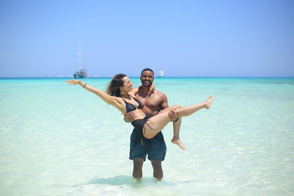 een man en een vrouw staan in het water op het strand