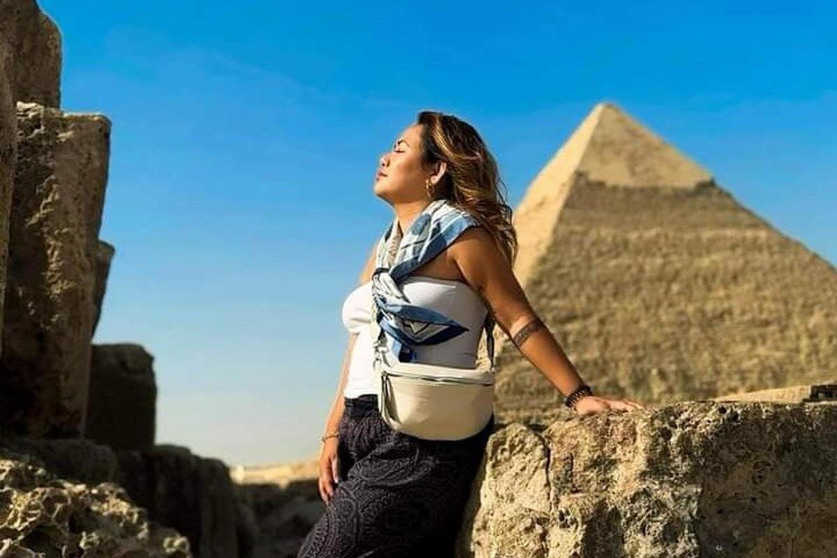 una donna in piedi in cima alle piramidi