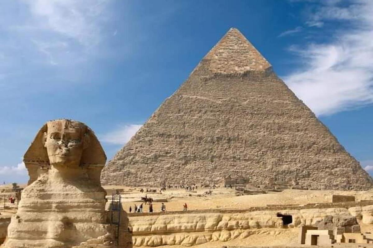 una piramide e una statua di fronte a una piramide