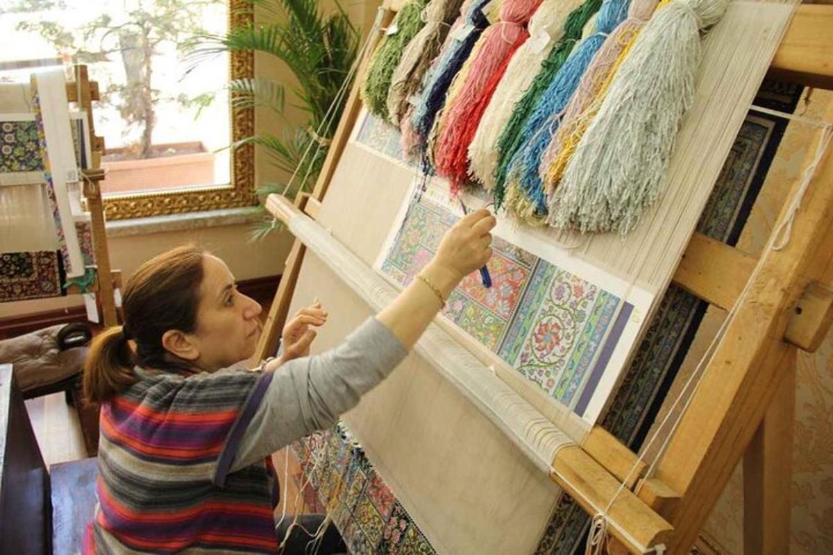 una donna che lavora a un'opera d'arte su un muro