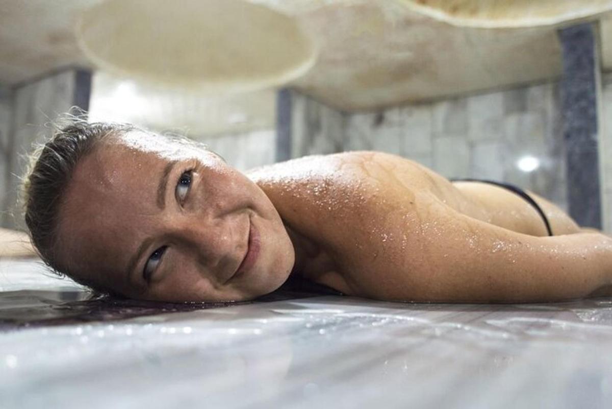ein Mann, der in einer Badewanne im Wasser liegt