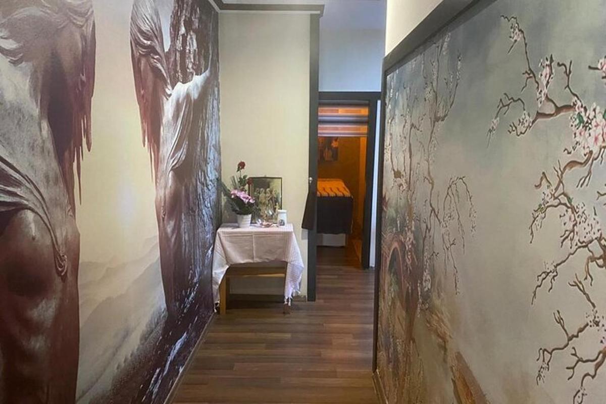 Un pasillo con una mesa y cuadros en la pared.